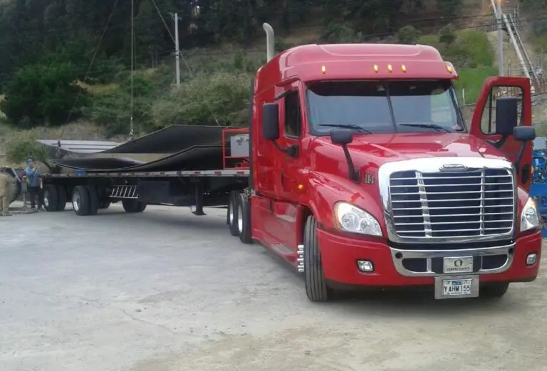 Red semi-truck hauling metal sheets.