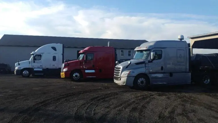 Three semi-trucks parked in a lot.